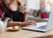 Beautiful woman relaxing at home with notebook and cup of  coffee